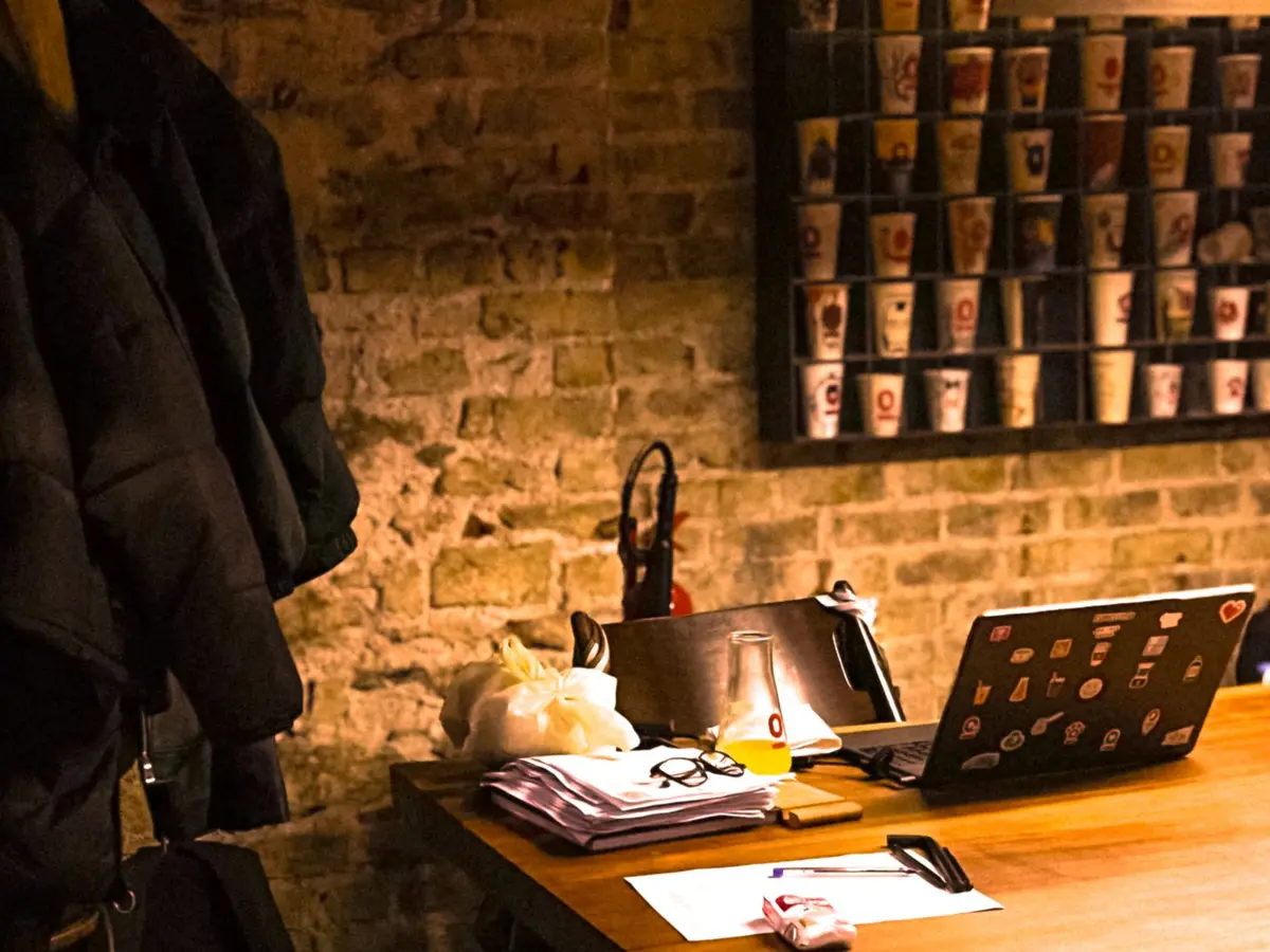 Een laptop op een bureau met papieren ernaast