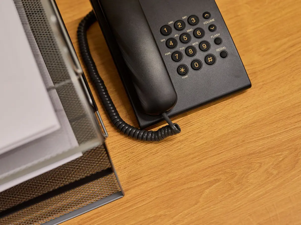 Vaste telefoon en een documentenbak op een bureau