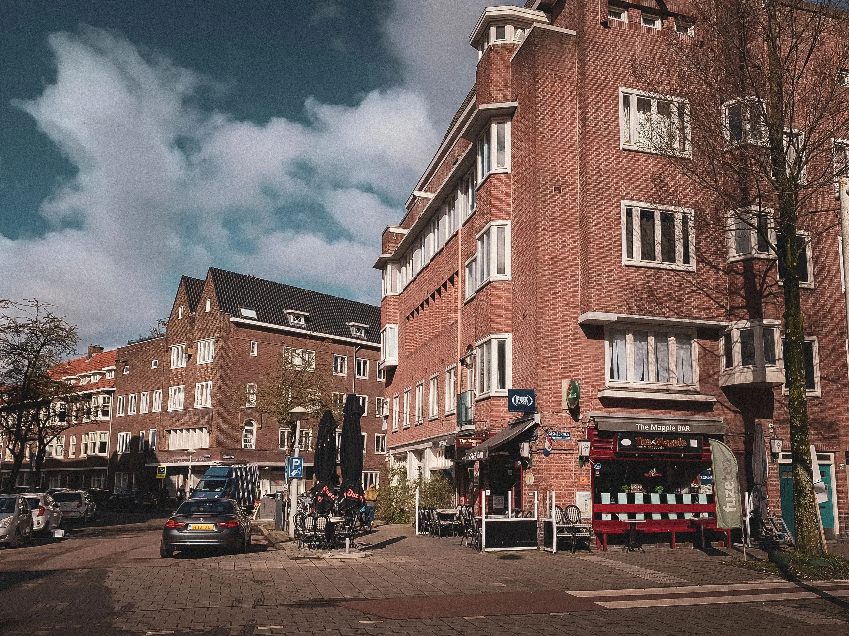 Straathoek met een cafe en een terras in een Nederlandse woonwijk