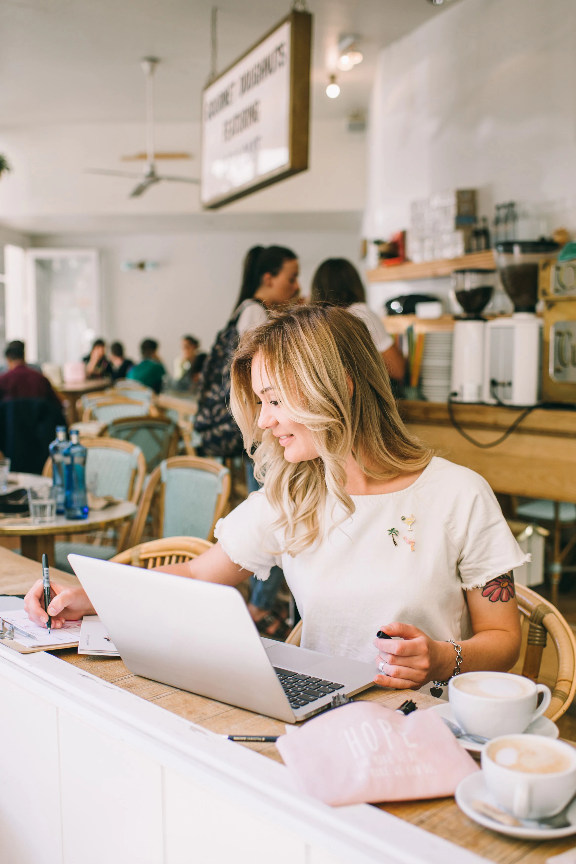 Een ondernemer werkt op haar laptop aan een tafel in een café
