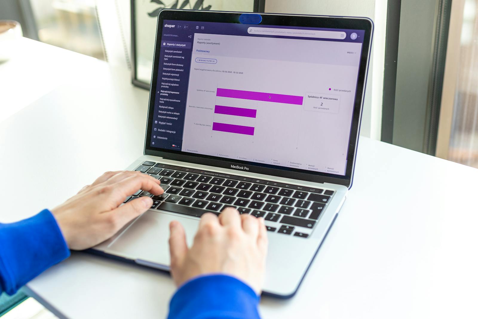 Laptop met dashboard waarop moderne domeinextensies zoals .ai, .io, .app, .shop en .tech worden vergeleken op prijs en kenmerken