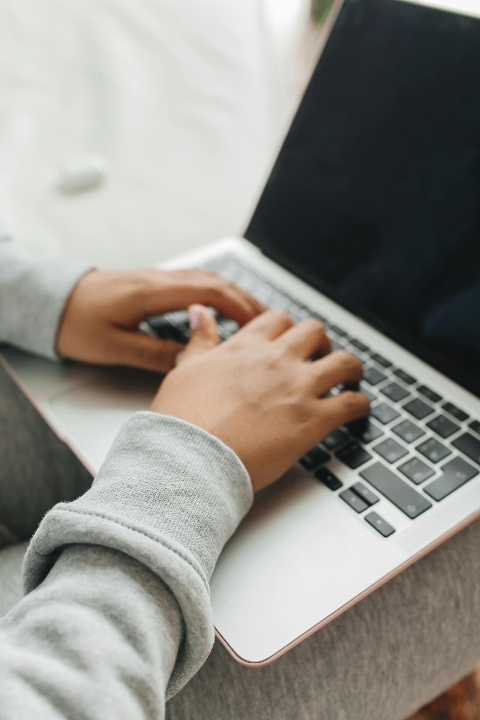 Persoon typt op laptop tijdens het registreren van een nieuwe domeinnaam