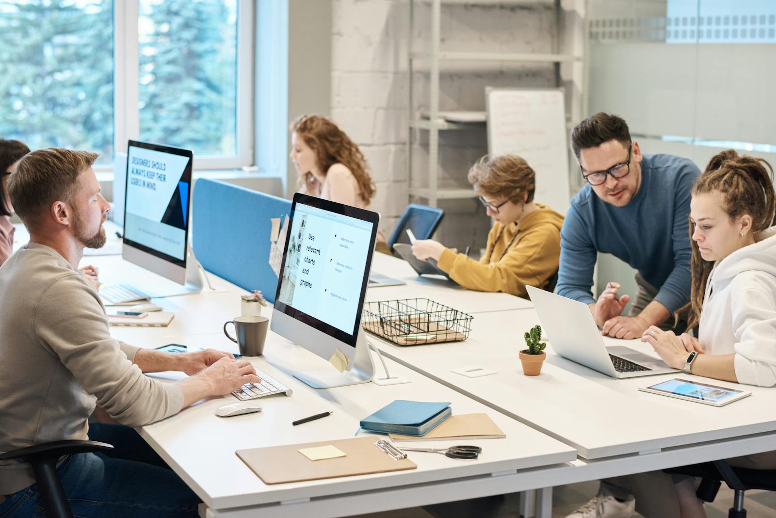 Team van MKB-medewerkers werkt samen op laptops met Microsoft 365 in een modern kantoor