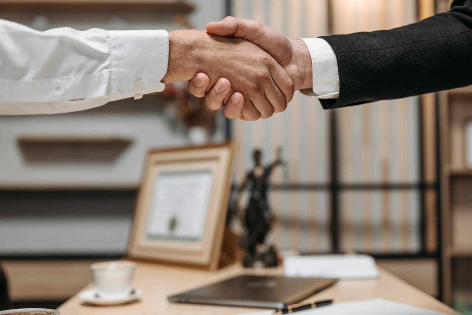 Close-up van een handdruk tussen twee professionals, symbool voor het kiezen van de juiste WordPress onderhoudspartner
