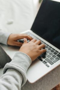 Persoon typt op laptop tijdens het registreren van een nieuwe domeinnaam