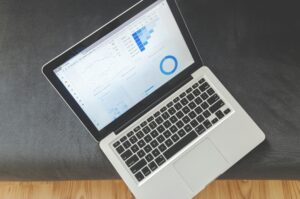 Laptop met performance dashboards en grafieken illustreert managed WordPress hosting met LiteSpeed voor snelle laadtijden