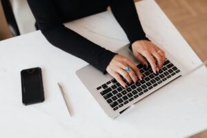 MKB-ondernemer aan een opgeruimd bureau met laptop in een lichte werkruimte, beslismoment over managed webhosting versus shared hosting