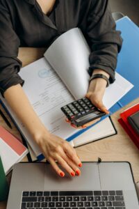 Ondernemer met calculator en laptop berekent de verborgen kosten van zelf WordPress beheren in 2026