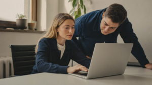 Op een phishinglink geklikt: medewerker en collega bekijken samen de laptop op kantoor